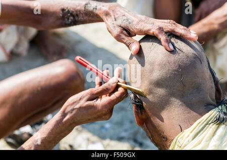 Pèlerin de se raser la tête au sangam, le confluent des fleuves Ganges, yamuna et saraswati, à kumbha mela Banque D'Images