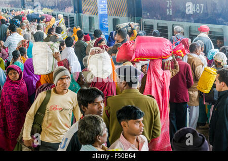 De nombreuses personnes en attente du retard de trains sur une plate-forme de la gare, poussant à l'intérieur d'un train arrivant Banque D'Images