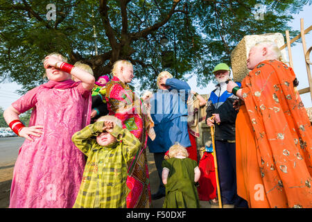 Une famille d'albinos, tous ont la peau extrêmement pâle et des cheveux blancs, est debout dans la rue et qui couvre leurs yeux d'e Banque D'Images