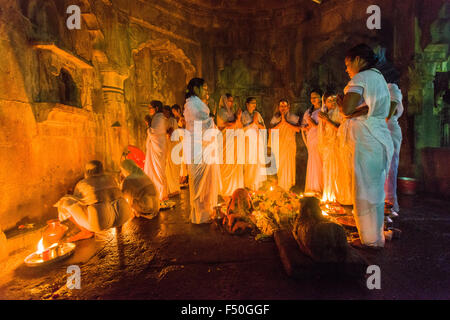 Un groupe de femmes est d'effectuer un rituel en utilisant des bougies dans l'un des temples de nuit Banque D'Images