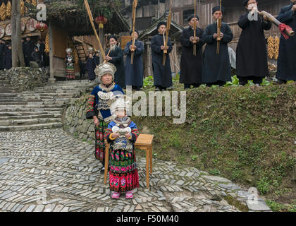 La mère et l'enfant et bande Lusheng, 'bloquer le chemin' cérémonie du vin de riz, Langde Shang Village Miao, province de Guizhou, Chine Banque D'Images