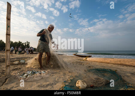 Un pêcheur est la réparation des filets de pêche sur la plage Banque D'Images