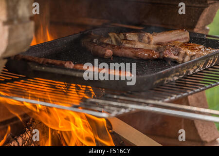 Dans la photo de saucisses et côtelettes de veau tout en étant cuit à la cheminée (barbecue). Banque D'Images