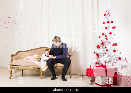 Heureux père jouer avec bébé daugter près de l'arbre de Noël. Banque D'Images