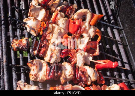 Une pile de brochettes de poulet, sur un barbecue Banque D'Images