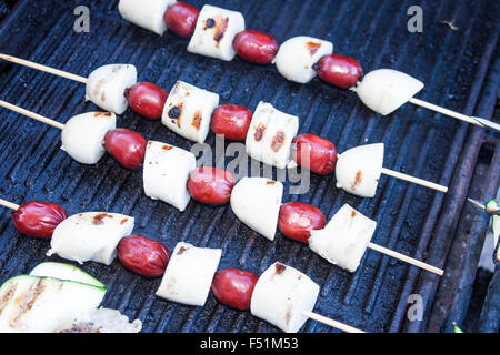 Griller les brochettes de saucisses Bratwurst et, sur un barbecue à gaz Banque D'Images