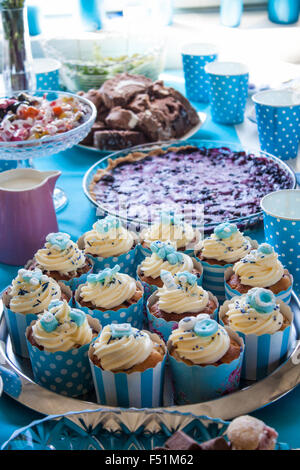Petits gâteaux de douche de bébé, à une table de travail. En face de tarte aux bleuets, les bonbons et les gâteaux au chocolat Banque D'Images