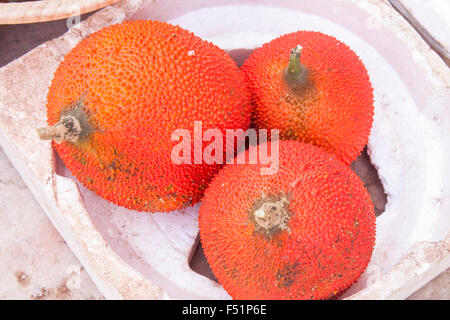 Quelques fruits rouges gourd ou GAC, à un marché Banque D'Images