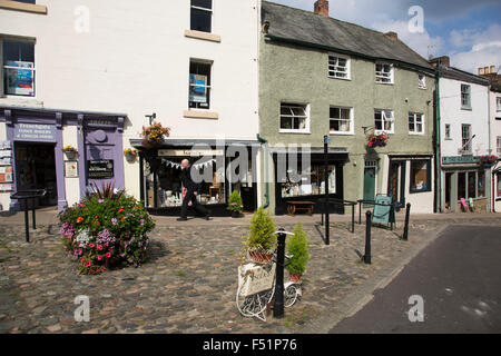 Richmond est une ville de marché et le centre de l'arrondissement de Richmondshire. Historiquement, dans la circonscription de North Yorkshire, elle est située au bord du Parc National des Yorkshire Dales. North Yorkshire, Angleterre, Royaume-Uni. Les commerces locaux dans l'église Trinity Square. Banque D'Images