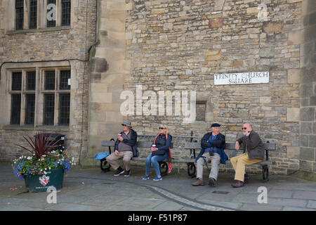 Richmond est une ville de marché et le centre de l'arrondissement de Richmondshire. Historiquement, dans la circonscription de North Yorkshire, elle est située au bord du Parc National des Yorkshire Dales. North Yorkshire, Angleterre, Royaume-Uni. Les gens assis dehors sur des bancs à l'église Trinity Square. Banque D'Images