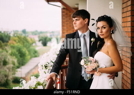 Beau jeune couple debout sur le balcon Banque D'Images