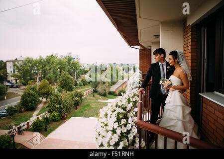 Beau jeune couple debout sur le balcon Banque D'Images