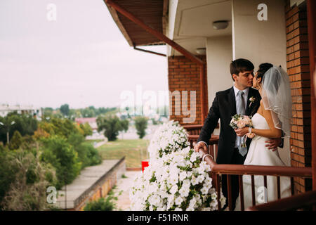 Beau jeune couple debout sur le balcon Banque D'Images