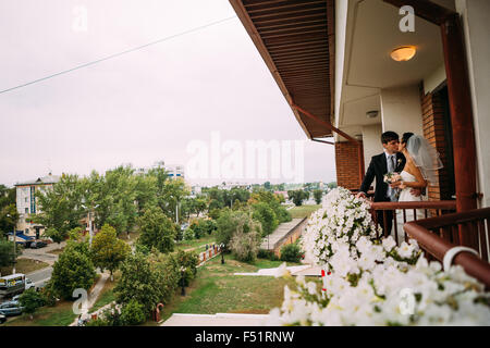 Beau jeune couple debout sur le balcon Banque D'Images