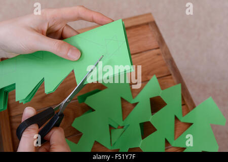 Faire une chaîne d'arbre de Noël des formes de papier vert Banque D'Images