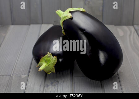 Deux aubergines sur une table en bois Banque D'Images