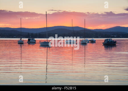 Lake Macquarie bateaux reflète dans l'eau toujours au coucher du soleil en arrière-plan montagnes Watagan Nouvelle Galles du sud , Australie Banque D'Images