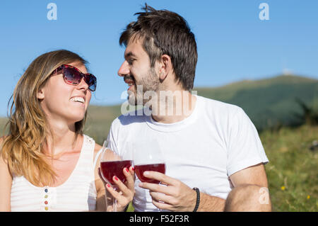 Young happy couple drinking wine en randonnée au viewpoint Banque D'Images