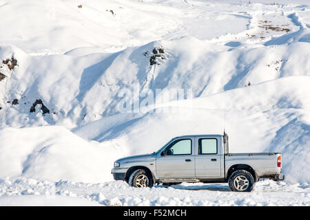 Voiture en hiver avec des marques sur la chaussée indiquant les capacités hors route Banque D'Images