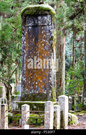 Le Japon, Koyasan, Okunoin cemetery. Pierre grave avec de la mousse verte et rouge, pour TAKEDA Shingen Takeda et Katsuyori. Bois de cèdre en arrière-plan. Banque D'Images