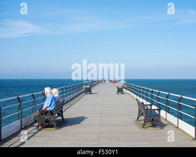 Les personnes âgées s'asseoir sur le siège de Lyon's Victorian Pier. Paris par la mer du Nord, en Angleterre, Yorkshre. UK Banque D'Images