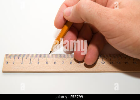 Men's main droite tenant un crayon sur un livre blanc Banque D'Images