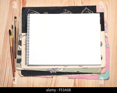 Ordinateur portable blanc, brosses et vieux papier feuille sur une surface en bois Banque D'Images