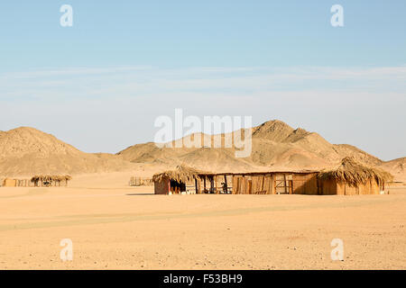 L'Afrique rurale traditionnelle reed et de chaume hut et paysage de montagne dans l'arrière-plan. Banque D'Images