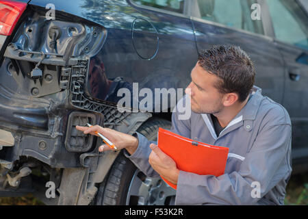 Voiture de mécanicien holding clipboard évaluation Banque D'Images