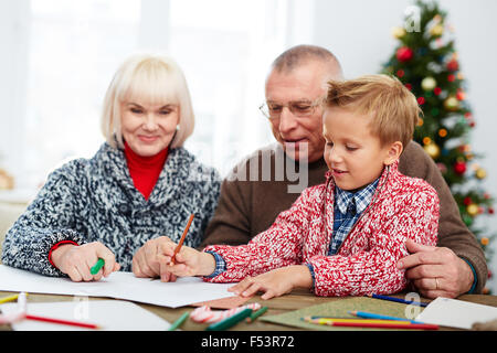 Boy écrit une lettre au Père Noël avec ses grands-parents Banque D'Images