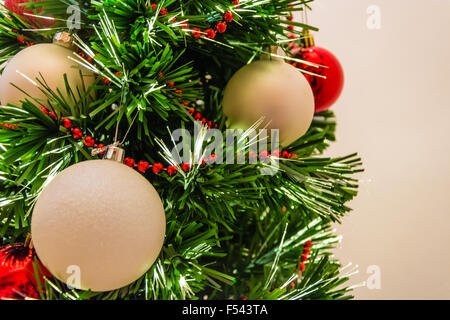 Près d'un arbre de Noël décoré avec des boules rouges et blanches Banque D'Images