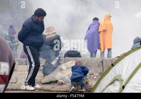 Spielfeld, Allemagne. 27 Oct, 2015. Les réfugiés se réchauffer par un incendie à la frontière dans Slovenian-Austrian Spielfeld, Allemagne, 27 octobre 2015. Plusieurs milliers de personnes sont bloqués dans le no man's land entre les deux pays. Photo : PETER ZSCHUNKE/dpa/Alamy Live News Banque D'Images