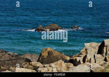 Vagues blanc en bleu de l'océan au large de la côte de Cornouailles près de St Ives briser contre les rochers Banque D'Images