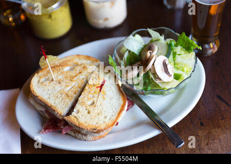 Deli sandwich pain géant avec de la moutarde et de la salade en bar diner restaurant à Soho, New York, USA Banque D'Images