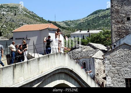 Jeune homme sautant d'ancien pont de Mostar. Banque D'Images