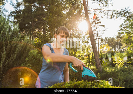 Jeune femme découpe at yard Banque D'Images