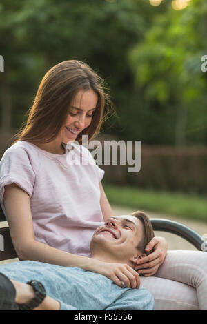 Happy young man lying on woman's lap à park Banque D'Images