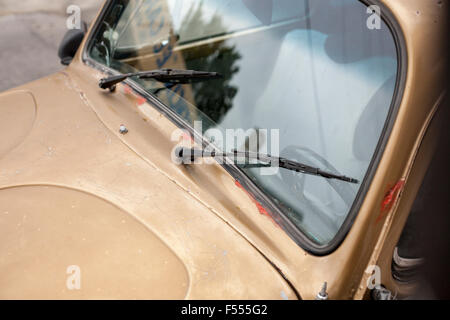 Golden coccinelle voiture. Un vieux rouillé ou Volkswagen Beetle Bug a une couche de peinture d'or mat. Il montre des fissures. Banque D'Images