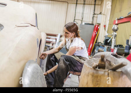 Femme mechanic repairing car à l'atelier de réparation Banque D'Images