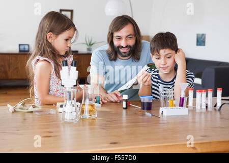 Heureux père et enfants faisant l'école à la maison de projet scientifique Banque D'Images