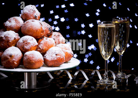 "Oliebollen", des pâtisseries pour le nouvel an et deux verres de champagne. Banque D'Images