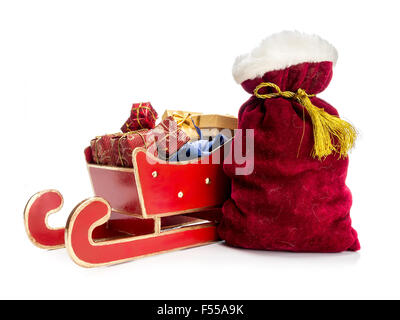 Traîneau rouge plein de cadeaux de noël et le Père Noël sac sur fond blanc Banque D'Images