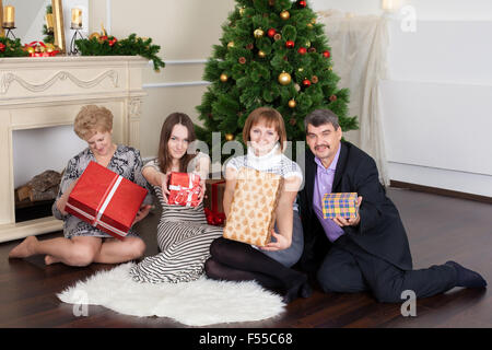 Famille heureuse dans la nouvelle année donne des cadeaux sous l'arbre de Noël Banque D'Images