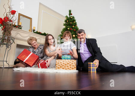 Famille heureuse dans la nouvelle année donne des cadeaux sous l'arbre de Noël Banque D'Images