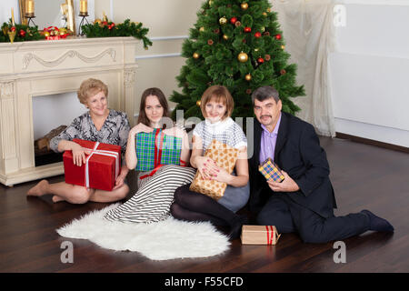 Famille heureuse dans la nouvelle année donne des cadeaux sous l'arbre de Noël Banque D'Images