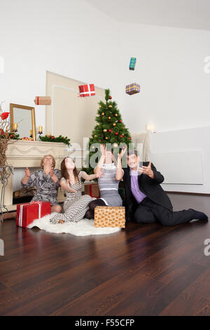 Famille heureuse dans la nouvelle année donne des cadeaux sous l'arbre de Noël Banque D'Images