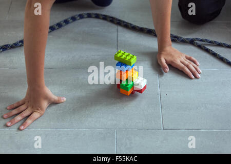 Les cubes en plastique dans les mains d'un jeu d'enfant qui développe la créativité et l'imagination, des briques lego Banque D'Images