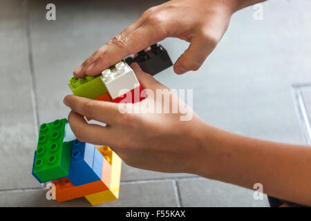 Les cubes en plastique dans les mains d'un jeu d'enfant qui développe la créativité et l'imagination Banque D'Images