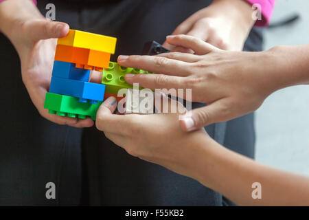 Les cubes en plastique dans les mains d'un jeu d'enfant qui développe la créativité et l'imagination, des briques lego enfants mains jouent avec des blocs lego Banque D'Images