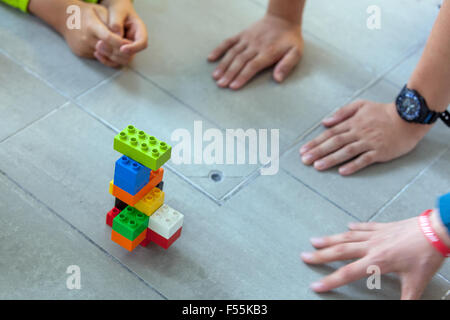 Les cubes en plastique dans les mains d'un jeu d'enfant qui développe la créativité et l'imagination, des briques lego enfants mains jouent avec des blocs lego Banque D'Images